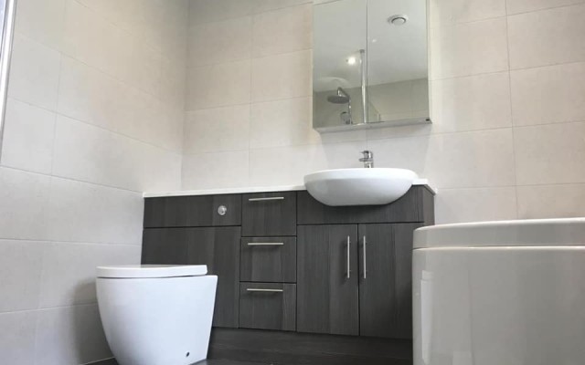 08 - K & L Heating & Bathroom Projects - Fitted Unit featuring a WC Unit and Vanity Basin with a Mirrored Cabinet